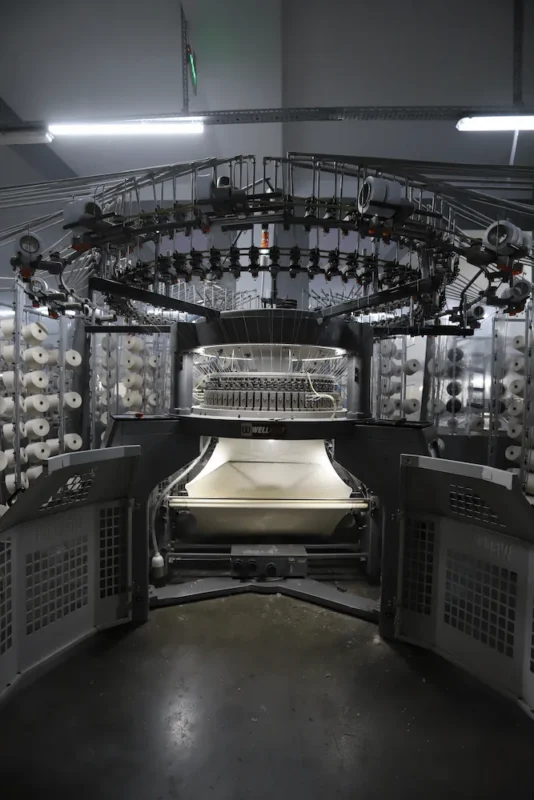 Knitted fabric production and quality control in a sustainable fabric manufacturing facility
